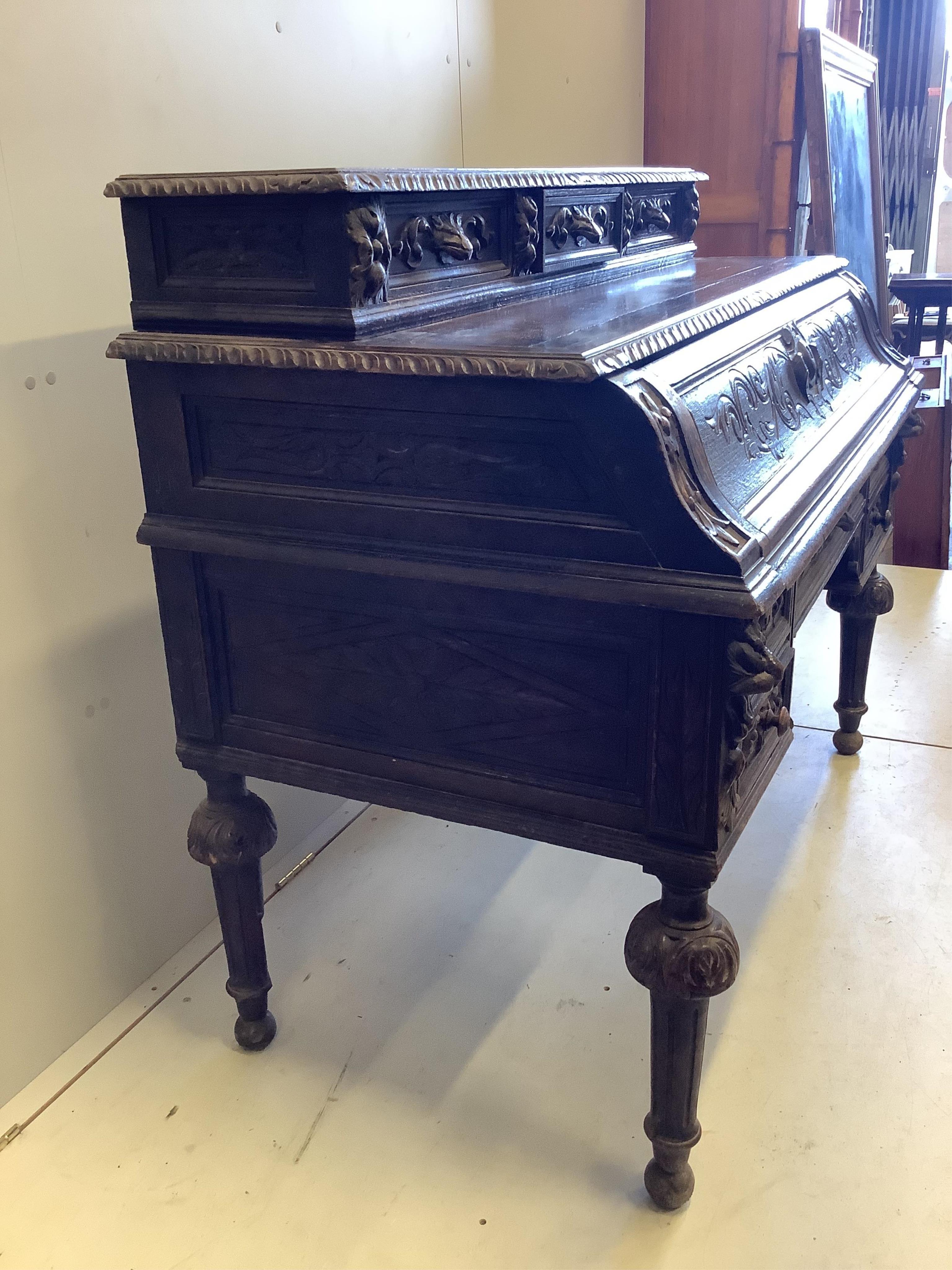 A late 19th century Flemish carved oak secretaire kneehole desk, width 129cm, depth 71cm, height 111cm. Condition - fair